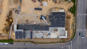 Vue aérienne d'un chantier en construction avec des équipements de chantier et des zones en cours d'aménagement.