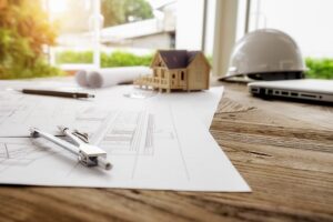 Plans de construction sur un bureau de travail avec des outils et un ordinateur portable